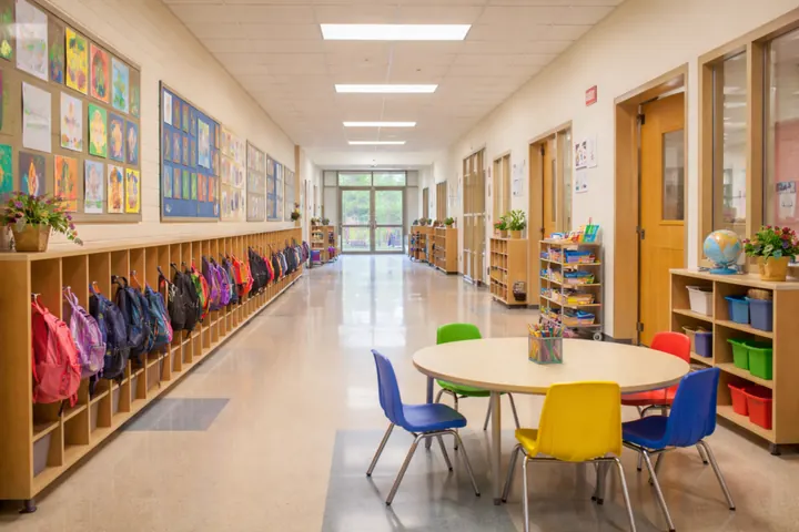 Local de garderie propre avec tables, chaises et espaces de rangement